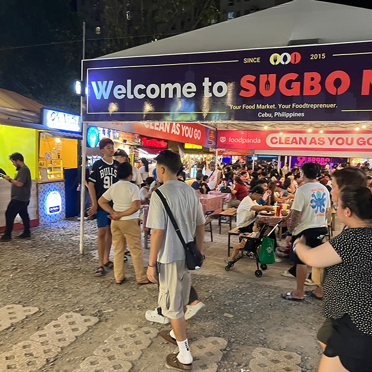 夜の屋外フードマーケットで人々が食事を楽しんでいる様子