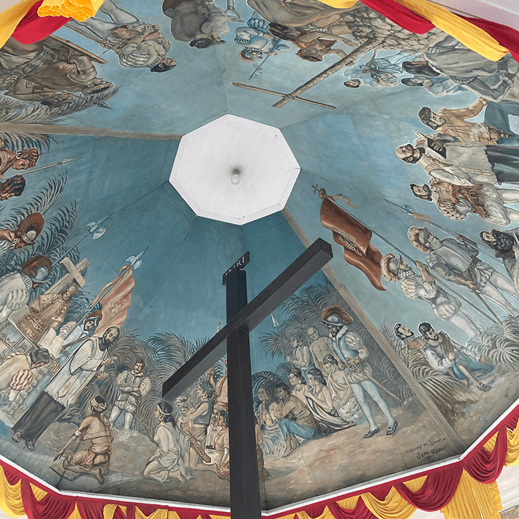 歴史的な場面を描いた天井の壁画を屋内から見上げた景色