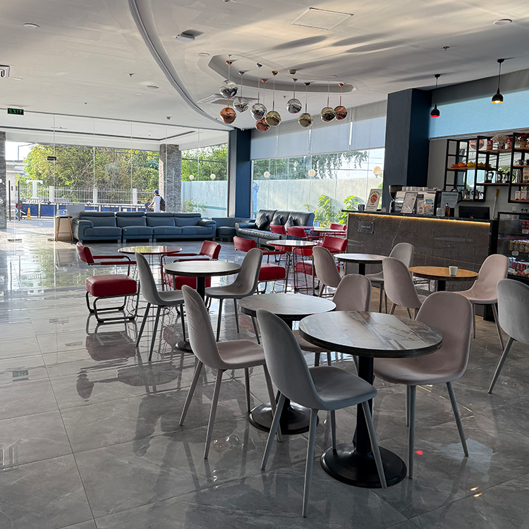 モダンなテーブルと椅子がある屋内のカフェスペースで大きな窓と光沢のある床