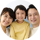 オンライン英会話を利用する小学生の女の子と両親の笑顔の家族写真