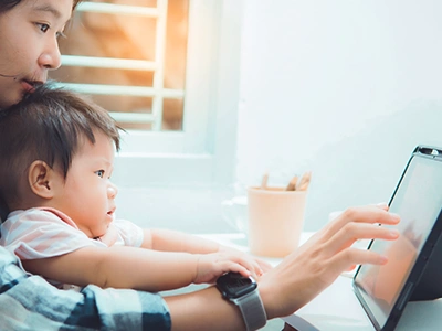 オンライン英会話の画面をタブレットで確認する母親と赤ちゃん